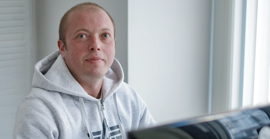 Mitarbeiter arbeitet am Laptop als Symbol für Weiterentwicklung und Support